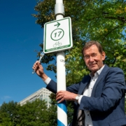 Gedeputeerde Rob van Muilekom plaatst symbolisch het eerste routebord van het vernieuwde recreatief fietsroutenetwerk.